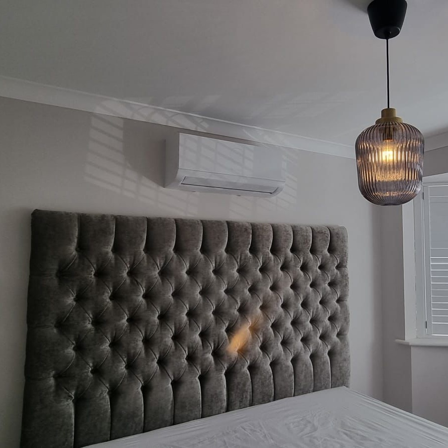 Air conditioning unit above a bed