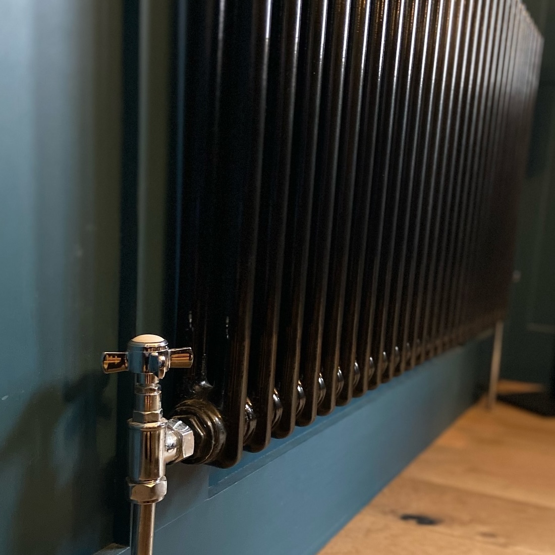 Black radiator on a blue wall
